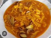 Una foto de almejas con fideos y azafran
