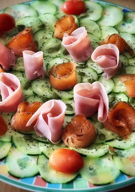 Una foto de Carpaccio de pepino con rosas de salmón y jamón