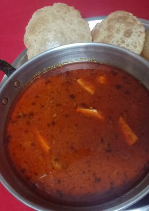 A picture of Tomato paneer gravy with ajwain puri.
