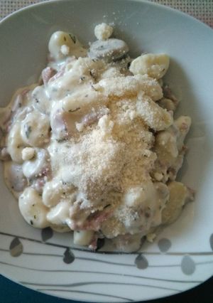 Una foto de Ñoquis con salsa de nata, jamón, queso y champiñones