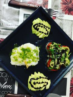 Una foto de Bacalao a la plancha con tambor de verduras y aguacate