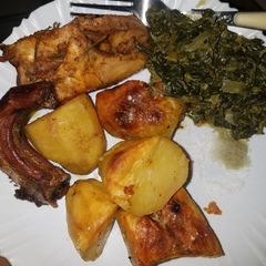 A picture of Oven roasted rosemary chicken with potatoes and greens.