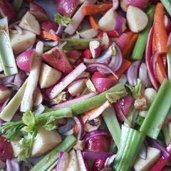 A picture of Roasted red potatoes, red raddishes, red onion, & carrots, leeks.