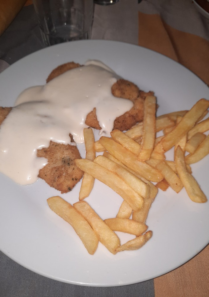 Una foto de Pechuga empanada con salsa de queso