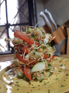 Una foto de Ensalada de tomate, pepino y germinados de lentejas