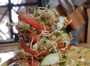 Una foto de Ensalada de tomate, pepino y germinados de lentejas