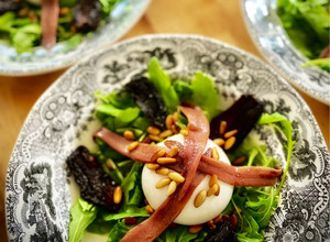 Foto principal de Ensalada de rúcula y burrata con anchoas de Santoña, tomate seco y piñones, sobre pesto de perejil