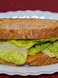 Una foto de Sándwich de salmón ahumado con queso azul, lechuga y guacamole