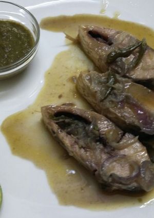 A picture of Stream Hilsa fish with green chilli and onion.