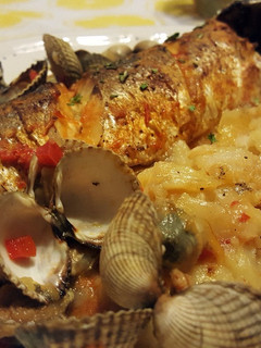 Una foto de Lubina al horno con patatas y berberechos