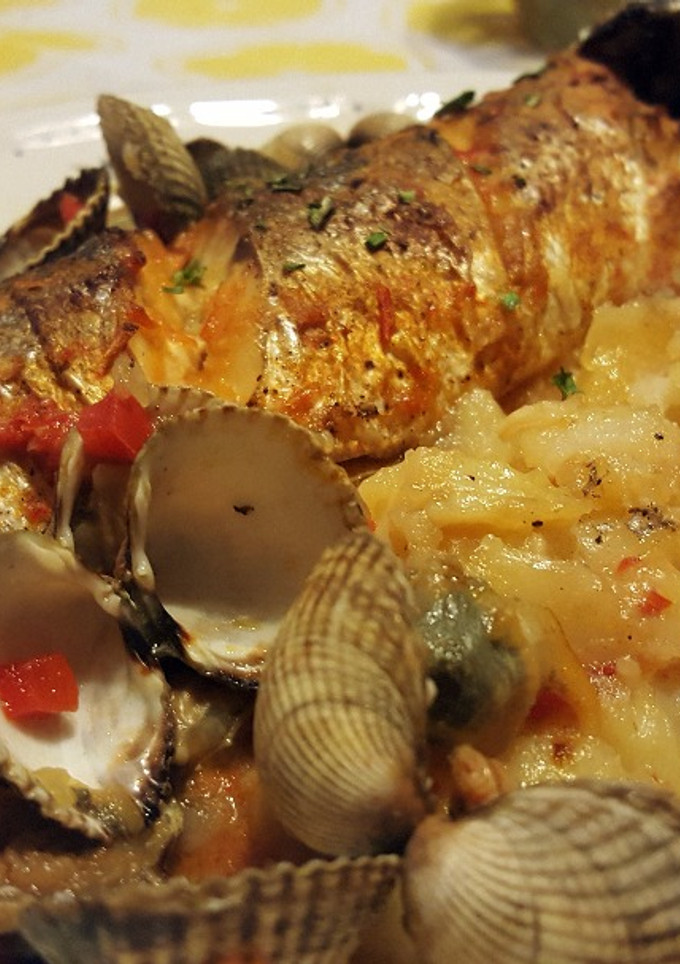 Una foto de Lubina al horno con patatas y berberechos