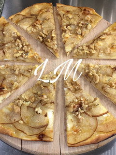 Una foto de Pizza de queso de cabra, pera, queso roquefort, nueces y miel