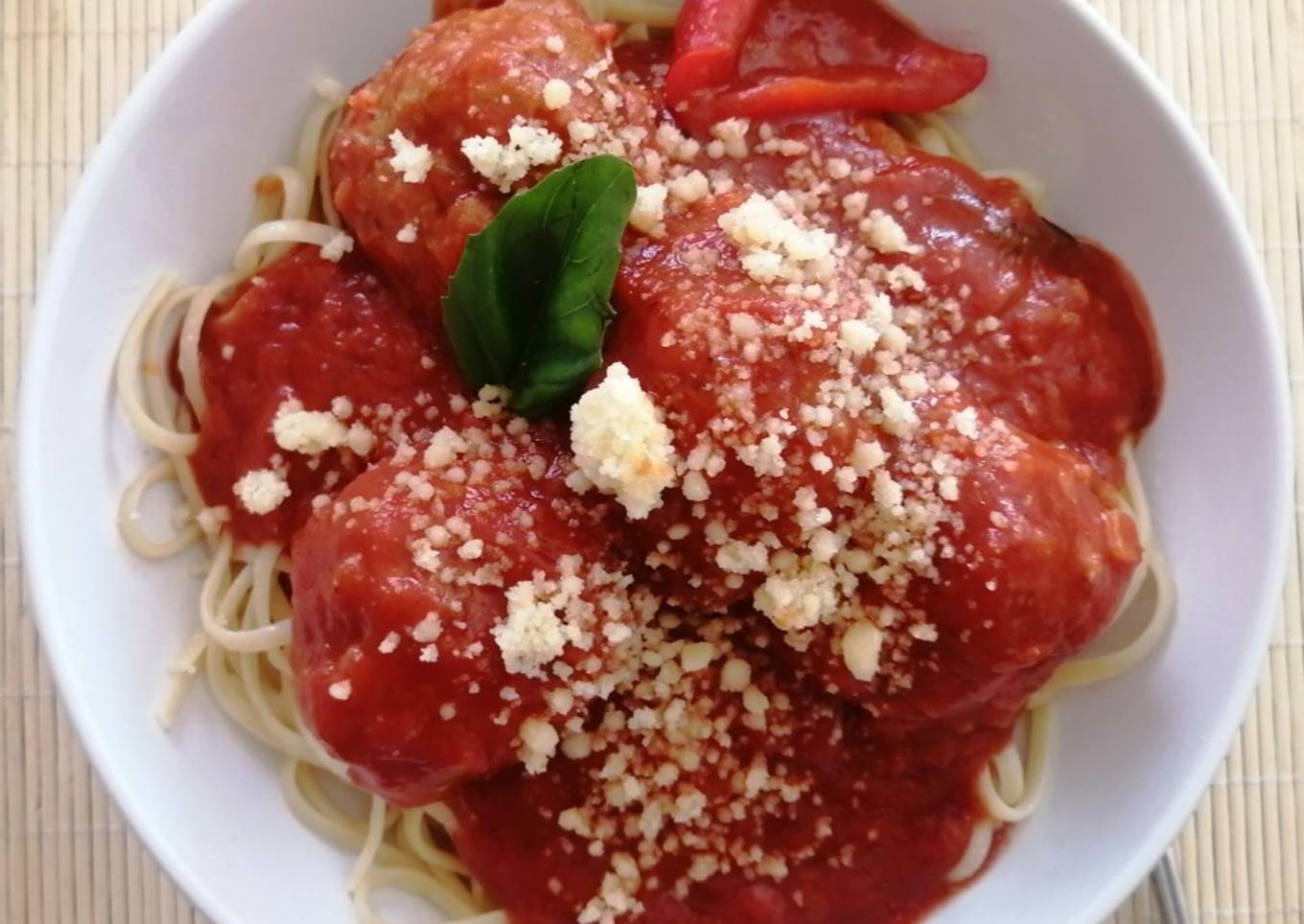 Spaghetti con albóndigas al pesto en salsa pomodoro