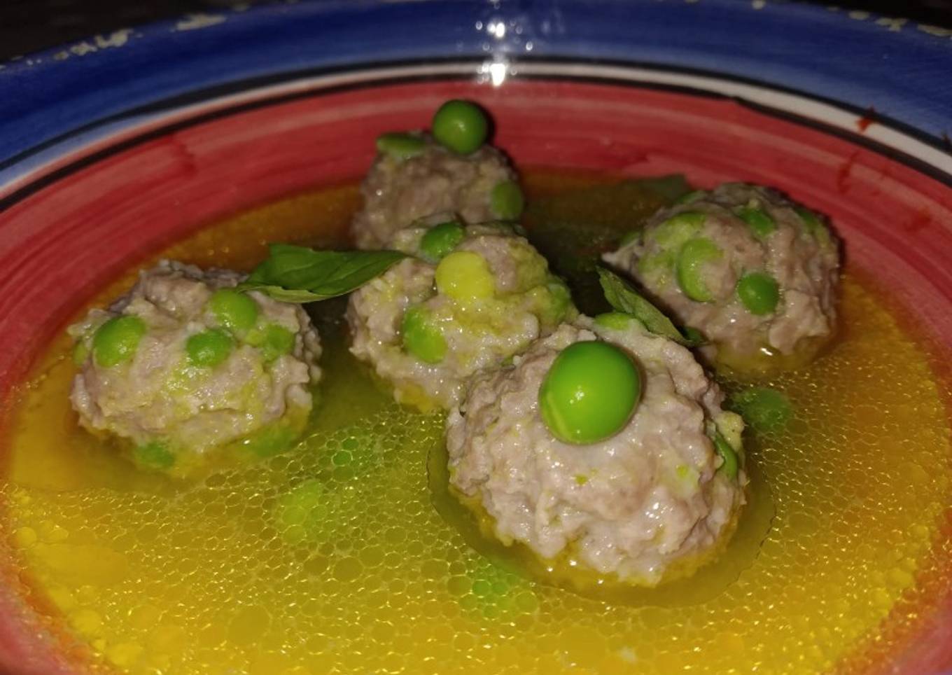 Albóndigas con guisantes en caldo de albahaca
