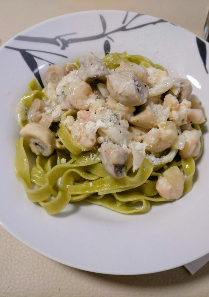 Una foto de Tagliatelle de espinacas con champiñones y gambas en salsa de queso