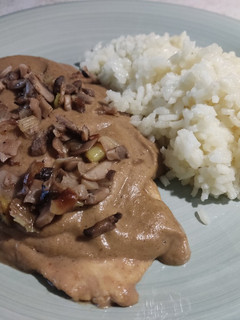 Una foto de Pechuga de pollo con salsa de setas y arroz blanco