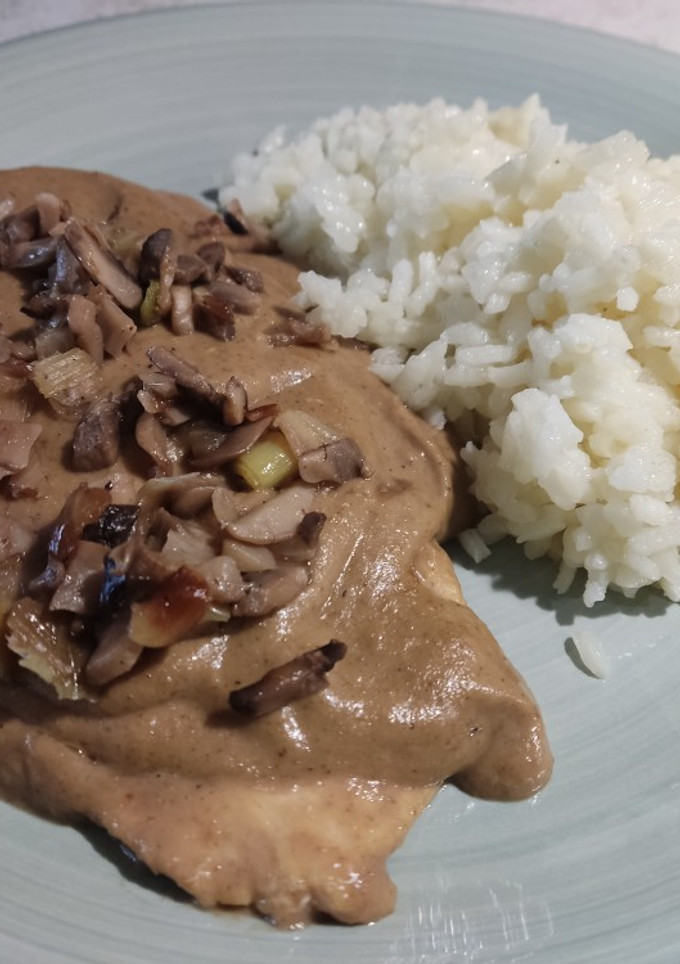 Una foto de Pechuga de pollo con salsa de setas y arroz blanco