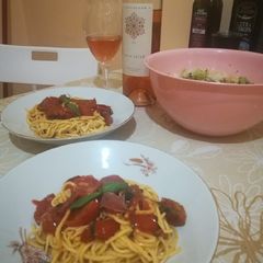 A picture of Pasta with cherry tomatoes and fresh basil.