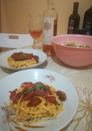 A picture of Pasta with cherry tomatoes and fresh basil.