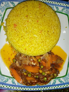 A picture of Yellow jollof rice with chicken beast sauce.