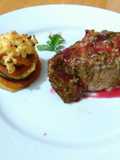 Carre de cerdo macerado en finas hierbas con salsa de cítricos y frutos rojos, con torre de vegetales gratinado