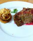 Carre de cerdo macerado en finas hierbas con salsa de cítricos y frutos rojos, con torre de vegetales gratinado