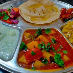 A picture of Peas potatoes and tomatoes curry.
