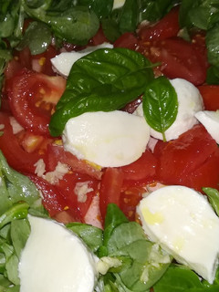 Una foto de Canónigos, tomate, mozzarella y albahaca