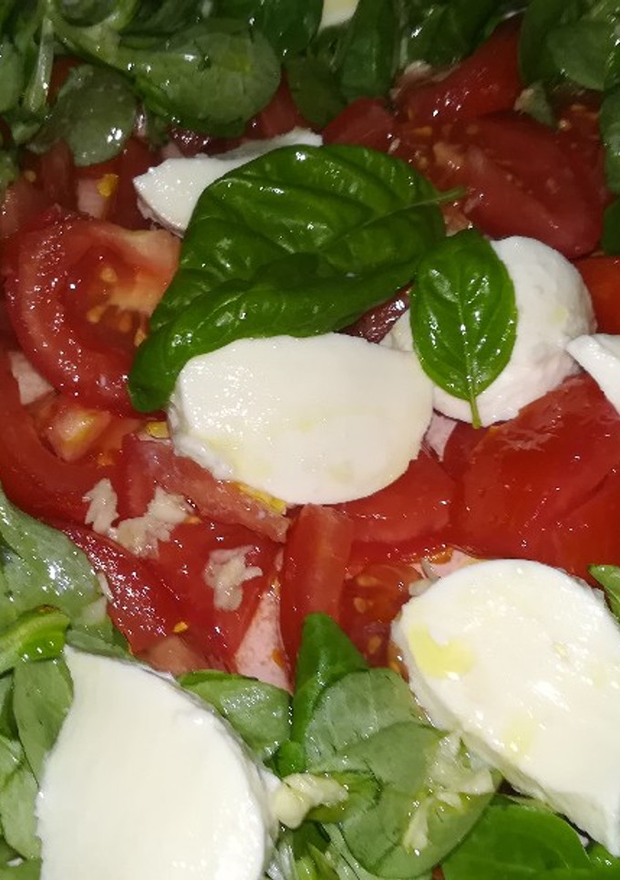 Una foto de Canónigos, tomate, mozzarella y albahaca