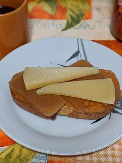 Una foto de Tostada integral con crema de cacahuete, membrillo y queso añejo fuerte