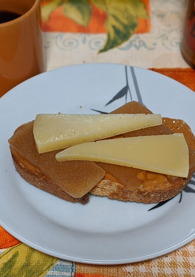 Una foto de Tostada integral con crema de cacahuete, membrillo y queso añejo fuerte