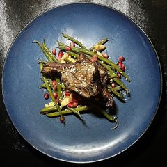 A picture of Asian lamb chops with fried beans and cashew nuts.