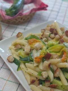 Foto di Pennette con fiori, foglie e frutto di zucchina