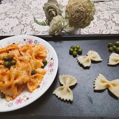 A picture of Creamy Red sauce Farfalle Pasta with green peas.