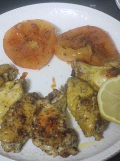 Una foto de Alitas de pollo al grill con tomate y limón