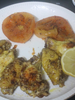 Una foto de Alitas de pollo al grill con tomate y limón
