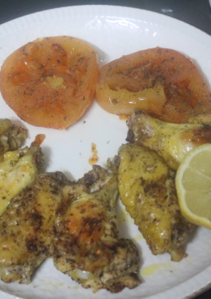 Una foto de Alitas de pollo al grill con tomate y limón