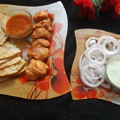 A picture of Chicken tikka with paratha and chutney.