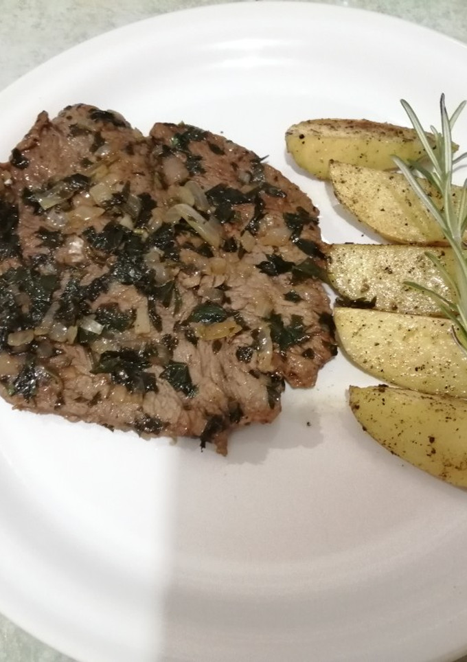 Una foto de Filete al perejil con papas rústicas