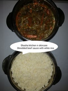 A picture of Shredded beef sauce with white rice.