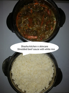 A picture of Shredded beef sauce with white rice.