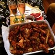 Alitas de pollo con una cama de papas fritas