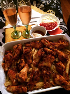 Una foto de Alitas de pollo con una cama de papas fritas