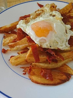 Una foto de Huevos rotos con crujiente de jamón serrano