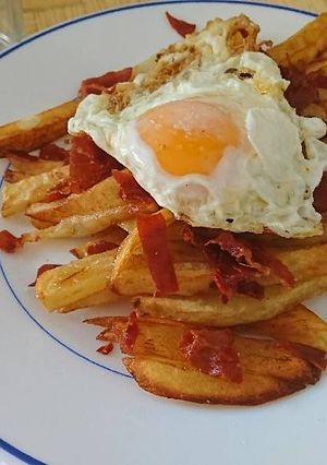 Una foto de Huevos rotos con crujiente de jamón serrano