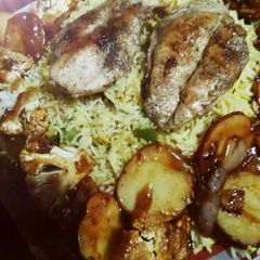 A picture of Chicken steak with red sauce and Grilled vegetables.