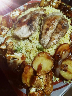 A picture of Chicken steak with red sauce and Grilled vegetables.