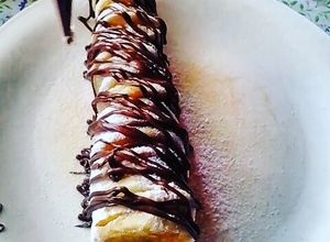 Una foto de Brocheta de mini hotcakes cubierta de chocolate y azúcar glass