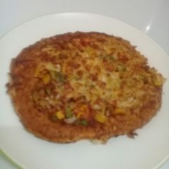 A picture of Home made pizza with vegetables n cheese toppings.