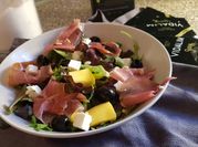 Una foto de ensalada de rúcula mango